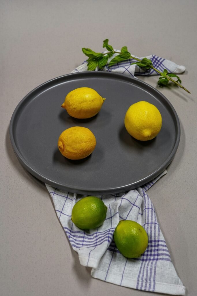 Lemons on a solid iron plate spreaded over a cloth with few mint leaves on the upper side